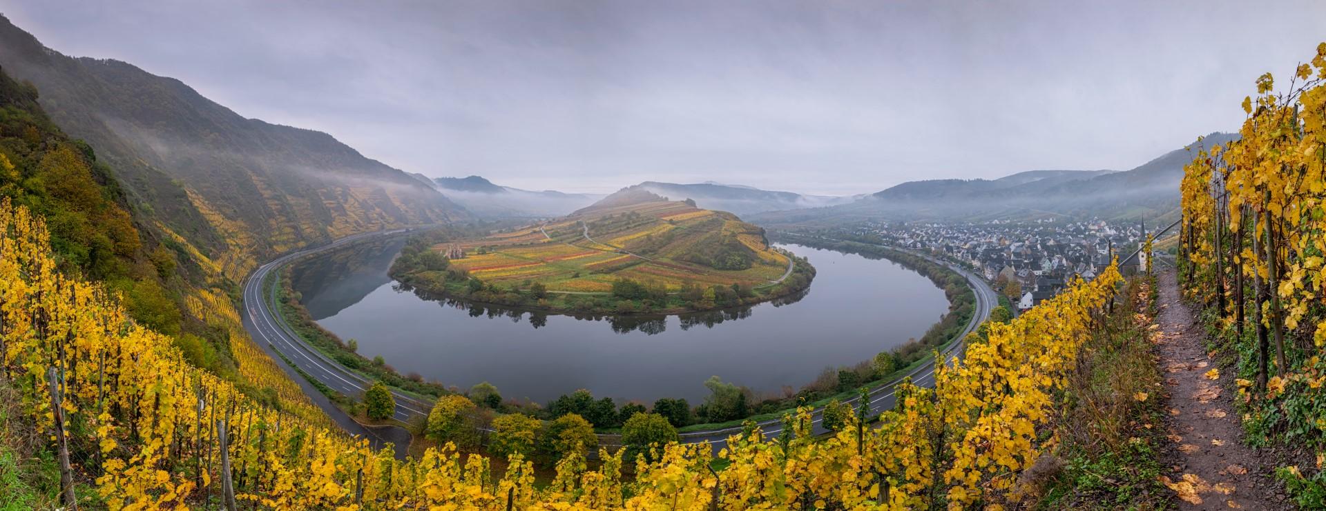 Een schitterend stuk Duitsland. Deze bocht van rivier De Moezel ligt nabij het plaatsje Bremm (deelstaat Rijnland-Palts, Landkreis Cochem-Zell, Duitsland). Vanaf een wandelpad door een wijngaard hadden we schitterend zicht op deze bocht. Met de herfstkleuren en de mist een schitterend stukje Duitsland!