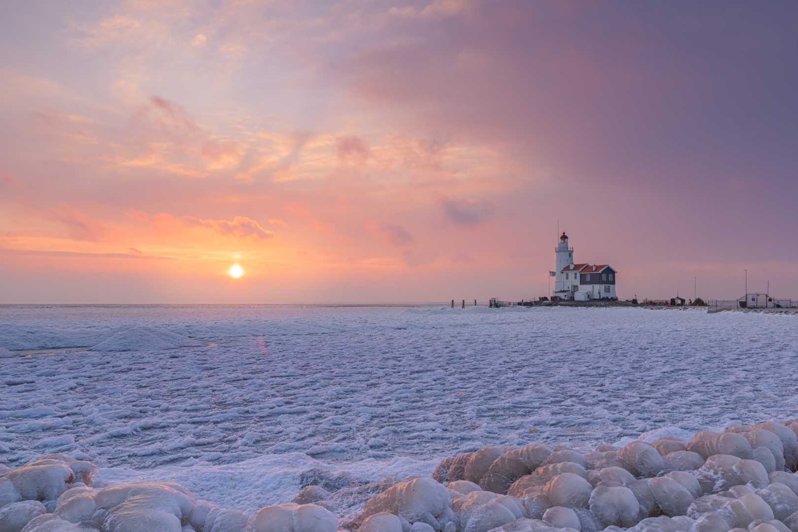 Vuurtoren Paard van Marken tijdens winterse omstandigheden. Het was ijzig koud, sneeuwbuien joegen over ons heen. We hadden bijna de hoop opgegeven, daar de lucht geheel bewolkt was. Vlak na zonsopkomst brak de lucht open en kregen we een schitterend schouwspel. Ondanks de -8 (gevoelstemperatuur -15) krijg je het toch warm! Voor dergelijke landschappen kom ik vroeg mijn bed uit!