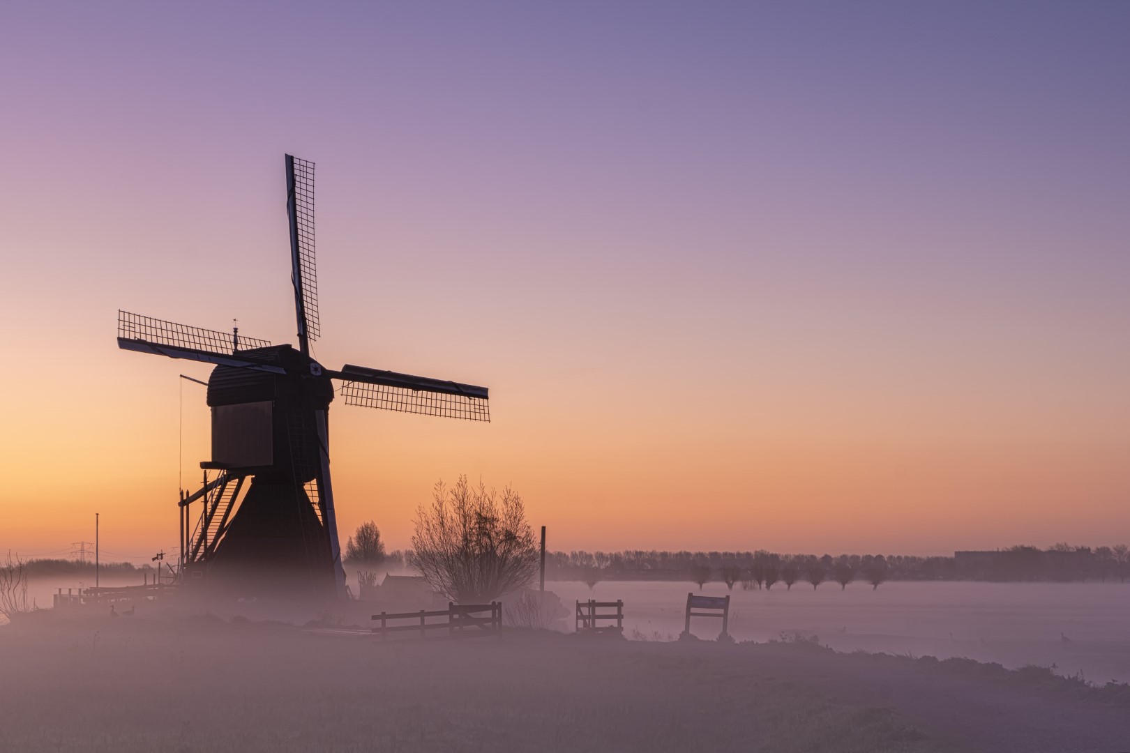 Deze foto is gemaakt op een msitige morgen, vlak voor zonsopkomst, in Werelderfgoed Kinderdijk (Zuid-Holland, Nederland). De avond ervoor hadden ze mist opgegeven, dus ik zou en moest naar de Kinderdijkse molens. Wat een mooie ochtend was dat. De kleuren, de mist en de natuur zorgden voor een serene rust.