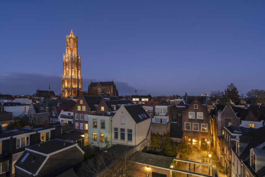 Deze foto van de Domtoren is gemaakt in Utrecht (Utrecht, Nederland). De zon is net onder gegaan, de lichten worden ontstoken. Ook de Domtoren wordt dan erg mooi verlicht. De toren steekt fier boven de stad uit en laat om het kwartier zijn klokkengeluid horen.