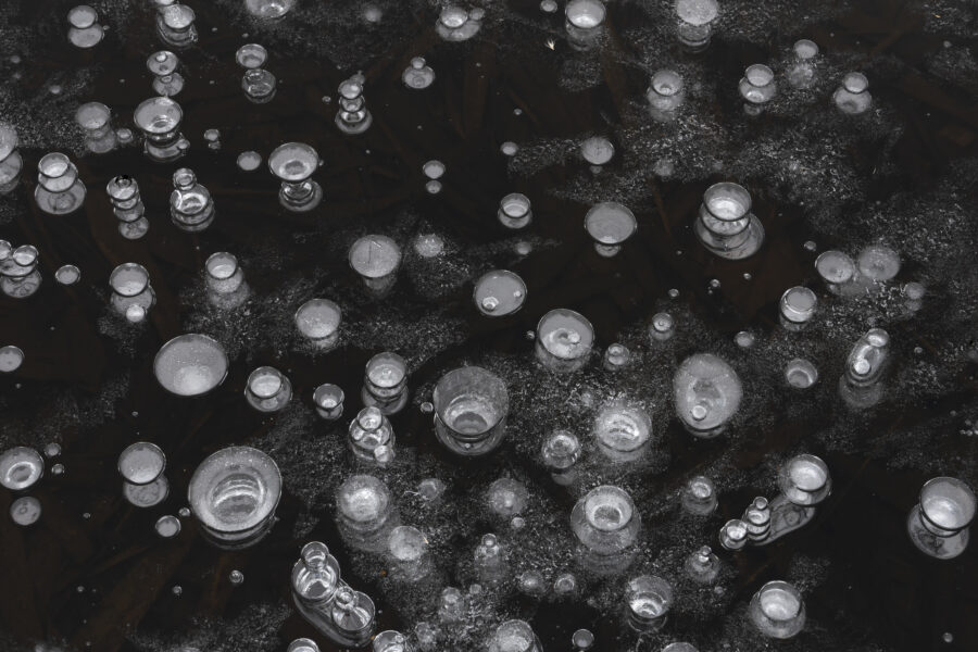 Luchtbellen is een detailfoto van natuurijs. Doordat de luchtbellen naar boven kwamen en tegen het ijs aan zaten, werden ze als dusdanig bevroren. Dit geeft een leuk effect in het ijs.