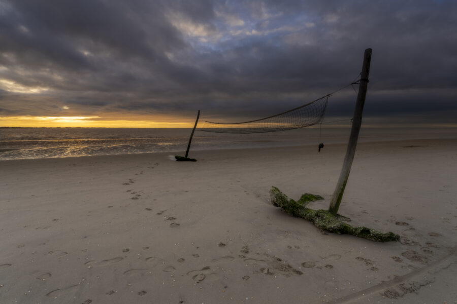 Deze foto is gemaakt aan het strand van Rockanje (Zuid-Holland, Nederland). Heel de dag was het grijs weer, maar 's middags vertoonde het wolkendek opeens gaten. En daarom maar naar deze plek gereden. Een schitterende zonsondergang, met een enorme gouden gloed viel me ten deel. Genoten aan dit strand!