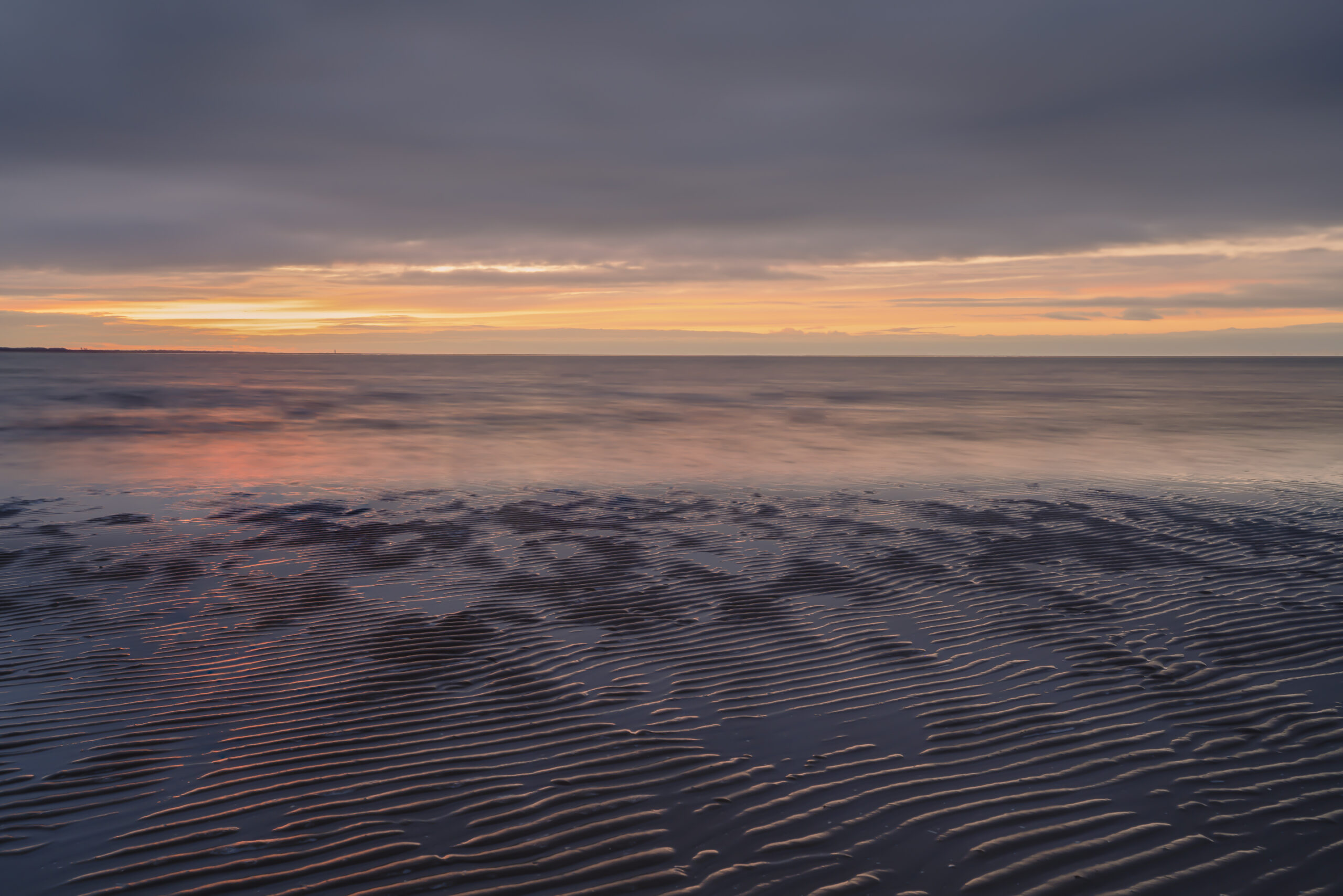 Deze foto Ribbels is gemaakt aan het strand van Rockanje (Zuid-Holland, Nederland). De zon ging schitterende onder en verspreidde zelfs daarna nog kleuren. Een mooie serene rust daalt neer over de zee.