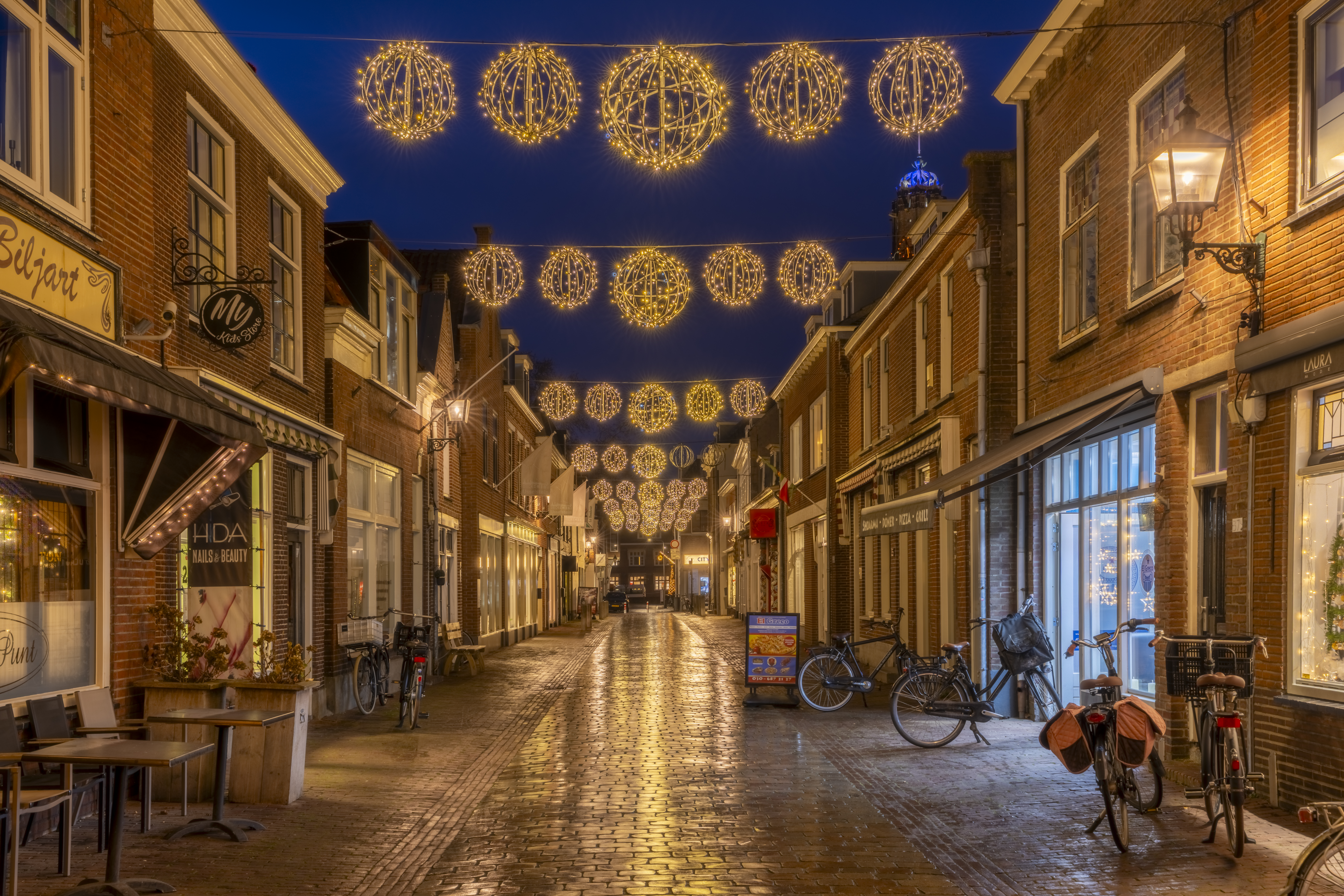 Een winkelstraat in kerstsfeer in IJsselstein (Utrecht, Nederland). Door de kerstverlichting ontstond een mooie sfeer. De vochtige stenen zorgden voor een fraaie reflectie.