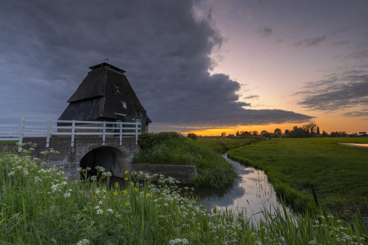 Zonsondergang bij de Sluismolen te Streefkerk (Zuid-Holland, Nederland). In 1979 is deze molen afgebrand en deels gerestaureerd. Het maakt onderdeel uit van een aantal molens aan de Tiendweg bij Streefkerk.
