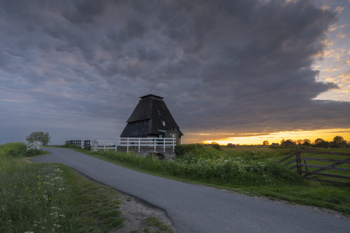 Zonsondergang bij de Sluismolen te Streefkerk (Zuid-Holland, Nederland). In 1979 is deze molen afgebrand en deels gerestaureerd. Het maakt onderdeel uit van een aantal molens aan de Tiendweg bij Streefkerk.