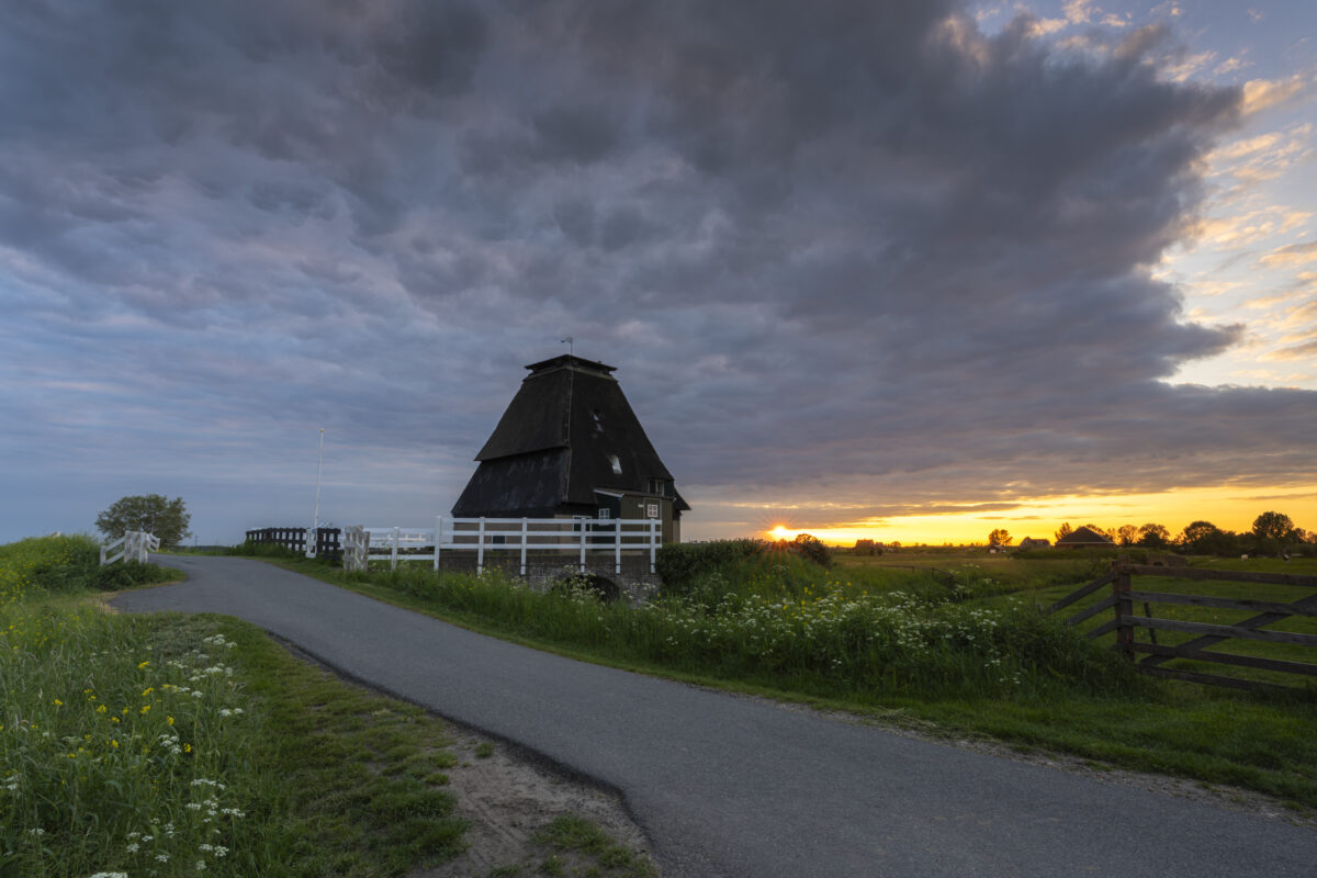Zonsondergang bij de Sluismolen te Streefkerk (Zuid-Holland, Nederland). In 1979 is deze molen afgebrand en deels gerestaureerd. Het maakt onderdeel uit van een aantal molens aan de Tiendweg bij Streefkerk.