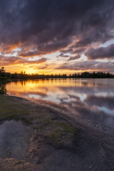 Een schitterende zonsondergang boven Nationaal Park De Biesbosch. Achter mij dreigde alweer een volgende onweersbui, maar voor mij ging de zon schitterend onder. Het zette de dreigende wolken in brand. Door het vele vocht in de lucht waren de kleuren nog intenser. Heerlijk om deze kleuren weerspiegelt te zien in het water. Een heerlijk moment om deze landschapsfoto te kunnen maken.